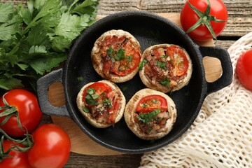Tasty stuffed mushrooms served on wooden table, flat lay