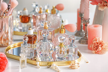 Bottles of different perfumes and accessories on dressing table indoors