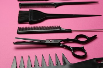 Different hairdresser's tools on pink background, closeup