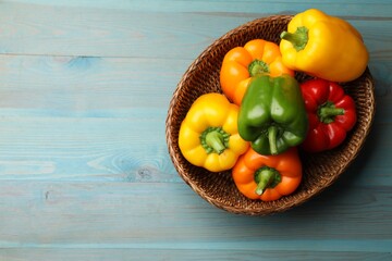 Fresh colorful bell peppers on blue wooden table, top view. Space for text
