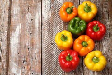 Fresh colorful bell peppers on wooden table, flat lay. Space for text