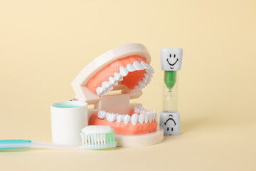 Different oral care products and dental model on beige background, closeup