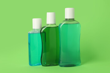 Different bottles of mouthwash on green background