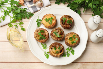 Tasty stuffed mushrooms served on wooden table, flat lay