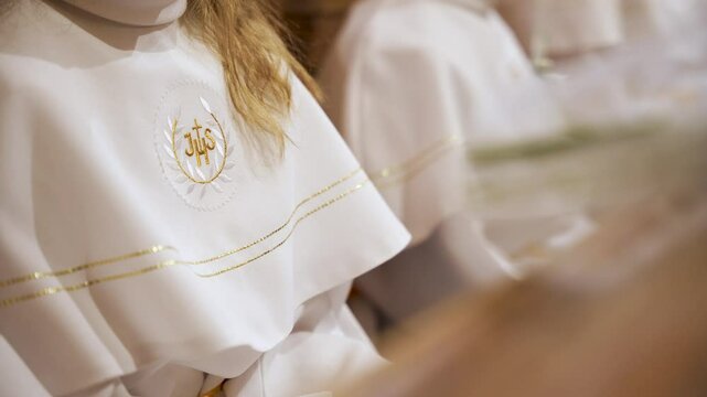 Blonde girl dressed as an altar boy in church. Close up. Receiving the first communion