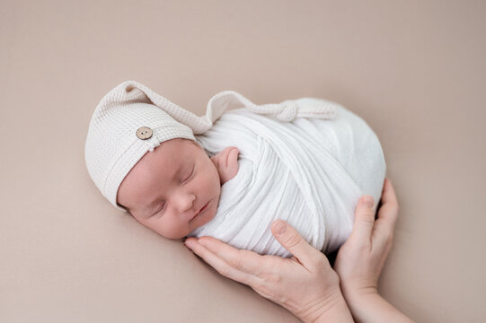Peaceful newborn baby wrapped in soft white blanket