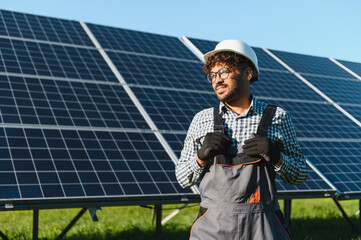 Engineer installing solar panels in a solar farm, renewable energy development