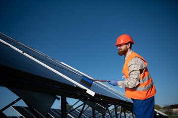 Technician cleaning solar panels for efficient green energy production