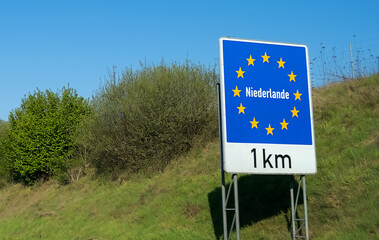 Road sign on the highway indicating the border of a country in the European Union: Holland. Written in German - Netherlands. Concept of entry restrictions into the EU and border checks.