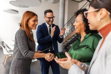 Business Professionals Shaking Hands in Office During Successful Meeting