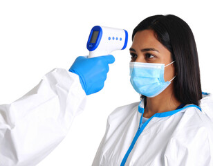 A healthcare worker in protective gear measures a masked woman"s temperature with a digital infrared thermometer against a black background.