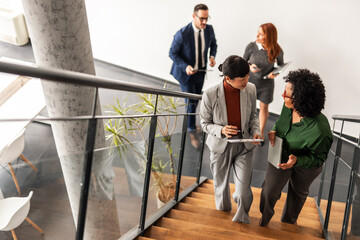Business Professionals Collaborating in Office Hallway During Work Discussion