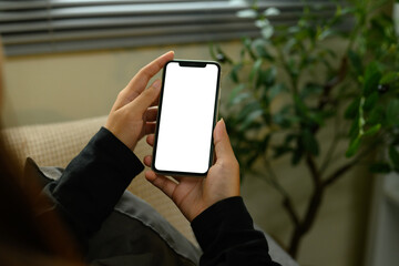 Close up view of woman holding smartphone with blank white screen