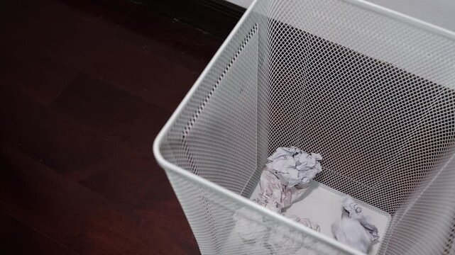 Close up of crumpled paper thrown into white aluminum trash