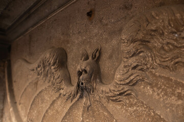 A stucco figurine in the form of a bat on the wall. A close-up photo of the stucco