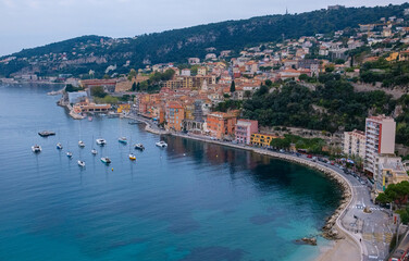 Panoramic view of the seaside resort town in France. Villefranche-sur-Mer, embankment with boats and blue crystal clear water of the sea