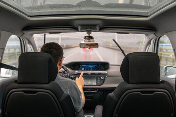 Driver gesture. Rainy drive. Car dashboard.