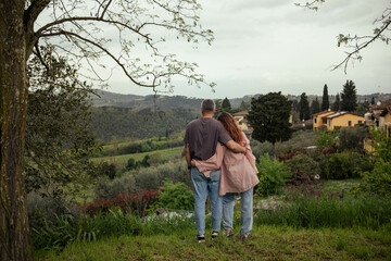Couple in love admiring the view of Tuscan nature. Beautiful landscape of Italian Tuscany, woman...