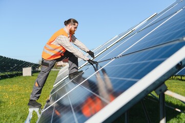 Worker installing solar panels in large solar farm