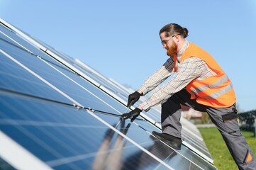 Technician installing solar panels in large solar farm