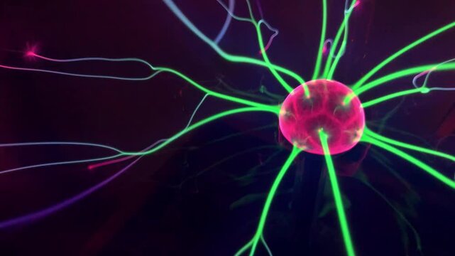 Moving colorful plasma filaments inside a plasma globe. Electric rays react to touch, creating a vivid display of energy and light. No people, close-up, abstract concept