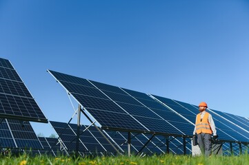 Engineer walking near solar panels in solar power station