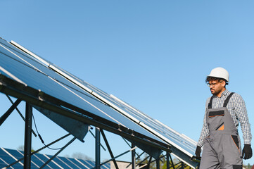 Arab Engineer walking near solar panels in solar power station on sunny day
