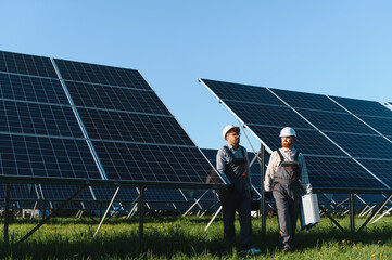 Workers walking and maintaining solar panels in solar power station