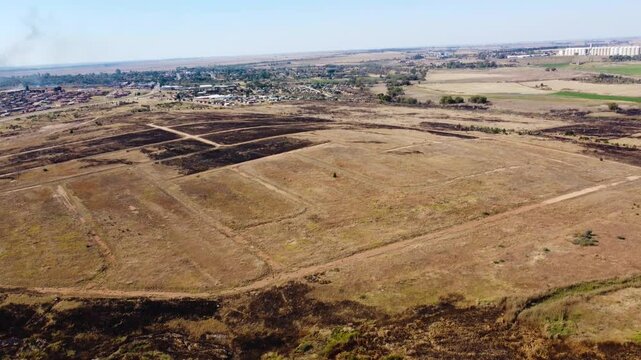  Camera panning up over dry brown agricultural land and the town of Venterdorp North West Province South Africa 4K Aerial Video