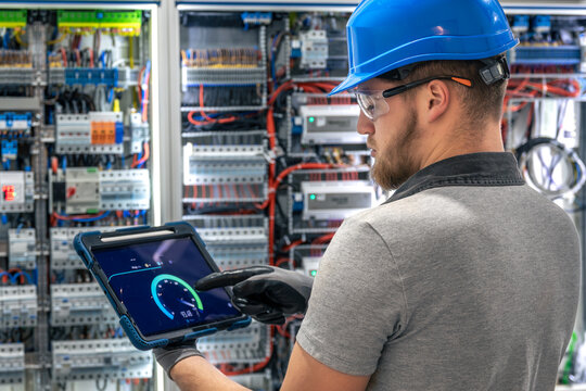 Electrician analyzing data. Tablet interface. Digital power monitoring.