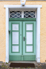Green classic door. Wooden detail. Vintage house facade.
