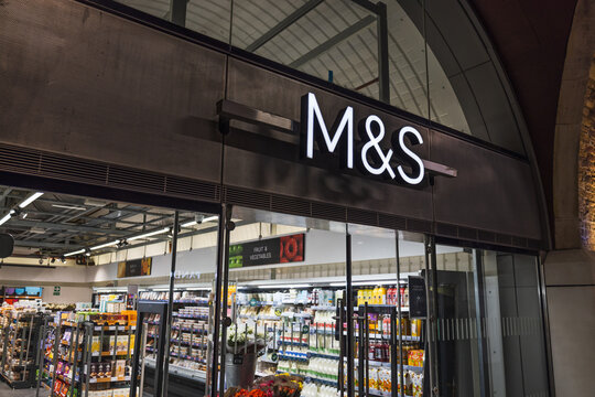Marks and Spencer store front sign illuminated above entrance. London, UK, 29 March 2024