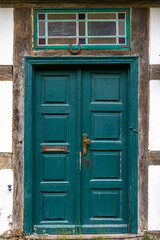 Teal vintage door. Scandinavian wooden facade. Brass handle and mail slot.