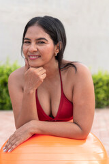 Latin woman relaxing after pilates workout with fitness ball