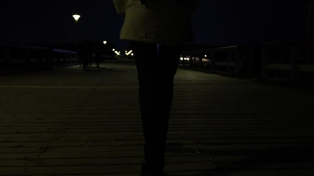 Slow motion view of woman walking alone, during the night. Stalker following victim. Dark night view, female legs.