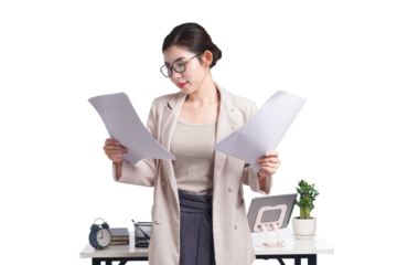Asian businesswoman posing next to desk full of documents