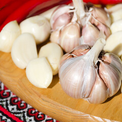 A few long, shiny red chili peppers, peeled garlic cloves, and a few whole heads of garlic.