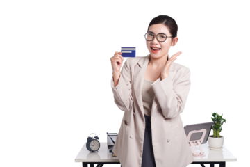 Asian businesswoman poses with bank card in hand, behind her is a table with lots of documents