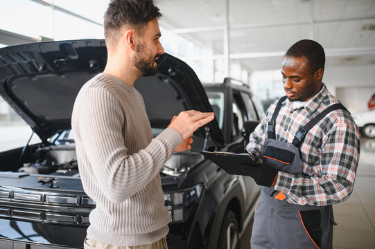 A satisfied client takes his repaired car to the mechanic. Car service station