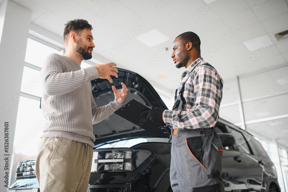 Poster man on the result of the work of a mechanic. the client evaluates the repair of the car by a mechani