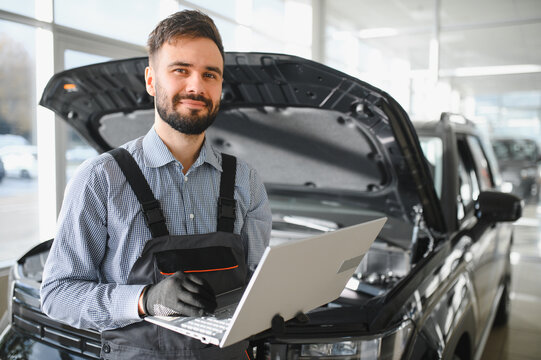 Automotive mechanic running diagnostics software on computer. Mechanic doing vehicle diagnostic test in auto service garage - Powered by Adobe