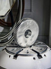 Precision metal gear placed on a machining table in a modern manufacturing facility during daylight hours