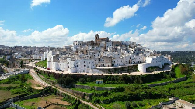 Ostuni - Italy, Apulia - approaching aerial view of the white city with a descending shot into the old town