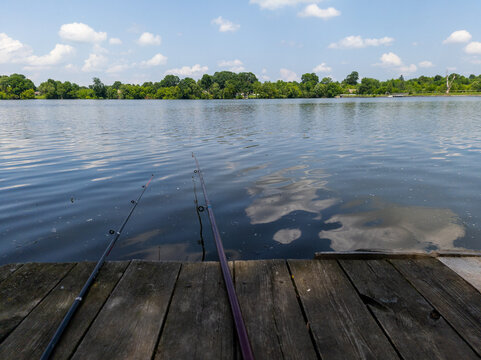 A wooden dock with two fishing rods on the water