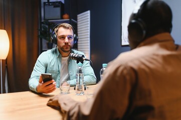 Podcast presenter having live discussion with man, streaming it for audience on internet...