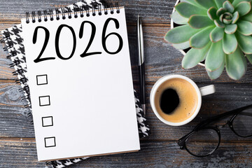 New year resolutions 2026 on desk. 2026 goals list with notebook, coffee cup, plant on wooden table. Resolutions, plan, goals, action, checklist, idea concept. New Year 2026 resolutions. Copy space