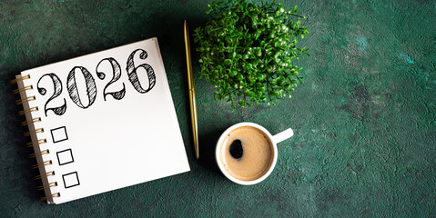 New year resolutions 2026 on desk. 2026 goals list with notebook, coffee cup, plant on wooden table. Resolutions, plan, goals, action, checklist, idea concept. New Year 2026 resolutions, copy space