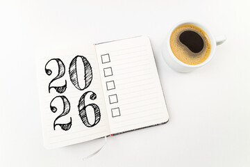 New year resolutions 2026 on desk. 2026 goals list with notebook, coffee cup on white. Resolutions, plan, goals, action, checklist, idea concept. New Year 2026 resolutions, copy space
