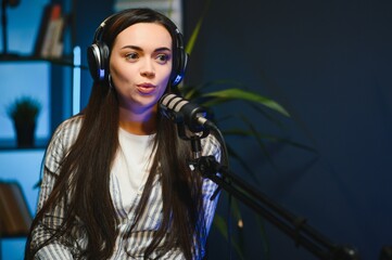 Female podcaster in headphones interviewing man guest using microphone, smiling, recording and...