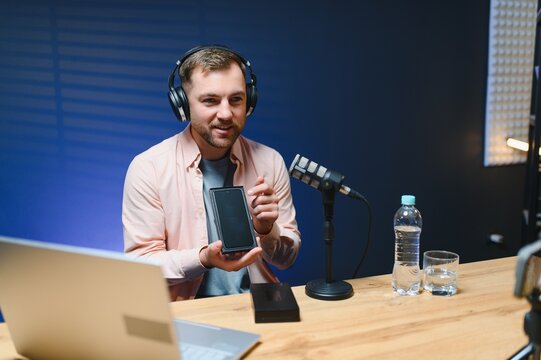 young adult man creating online content for the channel, daily vlog, unboxing a brand new phone at home, online sales